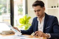 Young Asian businessman looking at market research report. Analyze statistical data in charts. Develop a growth strategy Work on a Royalty Free Stock Photo