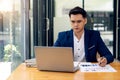 Young Asian businessman looking at market research report. Analyze statistical data in charts. Develop a growth strategy Work on a Royalty Free Stock Photo