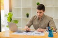 Young businessman looking at market research report Analyze statistical data in charts. Develop a growth strategy Work on a comput Royalty Free Stock Photo