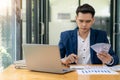 Young Asian businessman looking at market research report. Analyze statistical data in charts. Develop a growth strategy Work on a Royalty Free Stock Photo