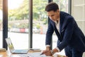 Young Asian businessman looking at market research report. Analyze statistical data in charts. Develop a growth strategy Work on a Royalty Free Stock Photo