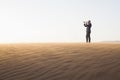 Young businessman looking through telescope in the middle of the desert Royalty Free Stock Photo