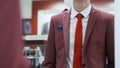 Young businessman looks at the mirror is suits shop