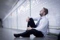 Young businessman lost in depression sitting on ground street subway Royalty Free Stock Photo
