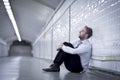 Young businessman lost in depression sitting on ground street subway Royalty Free Stock Photo