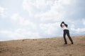 Young businessman lost and walking through the desert Royalty Free Stock Photo