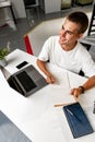 Young businessman making notes at tabletop with laptop in office Royalty Free Stock Photo