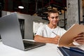 Young businessman making notes at tabletop with laptop in office Royalty Free Stock Photo