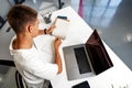 Young businessman making notes at tabletop with laptop in office Royalty Free Stock Photo