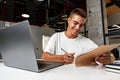 Young businessman making notes at tabletop with laptop in office Royalty Free Stock Photo