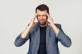 Young businessman man with a beard in a jacket. Hands on head, suffering from headache in despair and under stress due to pain and Royalty Free Stock Photo