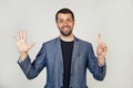 Young businessman man with beard smiling, showing number six with fingers on his hand, smiling confidently and happily, looking at Royalty Free Stock Photo