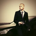 Young businessman with mobile phone next to his car Royalty Free Stock Photo