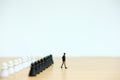 Young businessman move walking in front of chess pawn