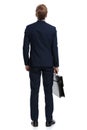 Young businessman in navy blue suit holding suitcase and looking up Royalty Free Stock Photo