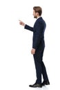 Young businessman in navy blue suit pointing finger to side Royalty Free Stock Photo