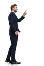Young businessman in navy blue suit pointing finger to side Royalty Free Stock Photo