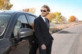 Young businessman near modern car on sunny day