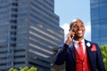 Young businessman outside in city and talking on mobile phone Royalty Free Stock Photo