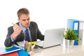 Young businessman overworked looking worried sitting at office computer desk in stress Royalty Free Stock Photo