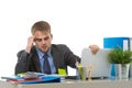 Young businessman overworked looking worried sitting at office computer desk in stress Royalty Free Stock Photo