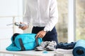 Young businessman packing sports stuff for training into bag Royalty Free Stock Photo