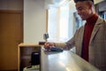 A young businessman is paying a bill at hotel reception during a business trip. Business, people, hotel, trip Royalty Free Stock Photo