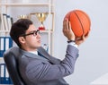 Young businessman playing basketball in office during break Royalty Free Stock Photo