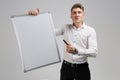 Portrait of young man with clean magnetic Board and marker in his hands isolated on white background