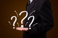 Young businessman presenting hand drawn question marks Royalty Free Stock Photo