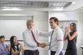 Young businessman promoted. Boss shaking hands with employee celebration for new position