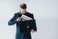 Young businessman putting newspaper in briefcase Royalty Free Stock Photo