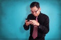 Young businessman reading text chat on his phone, happy smiling Royalty Free Stock Photo