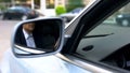 Young businessman reflecting in wing mirror of car, driving to office meeting