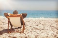 Young businessman relaxing on his sun lounger