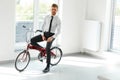 Young Businessman Rides on His Bike at Office. Business People Royalty Free Stock Photo