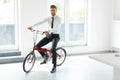 Young Businessman Rides on His Bike at Office. Business People Royalty Free Stock Photo