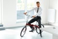 Young Businessman Rides on His Bike at Office. Business People Royalty Free Stock Photo