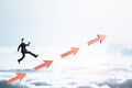 Young businessman runing on red arrows o