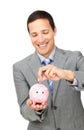 Young businessman saving money in a piggy-bank Royalty Free Stock Photo