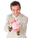 Young businessman saving money in a piggy-bank Royalty Free Stock Photo