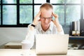 Young businessman seriously working on computer laptop in office