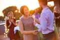 Young businessman shaking hands with mature businesswoman during rooftop party Royalty Free Stock Photo