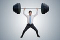 Young businessman in shirt is lifting heavy weights. Royalty Free Stock Photo