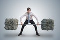 Young businessman in shirt is lifting heavy weights. Royalty Free Stock Photo