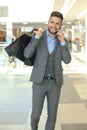 Young businessman with shopping bag talking on the phone indoors Royalty Free Stock Photo