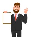 Young businessman showing blank clipboard and making okay, OK gesture sign. Person holding notepad. Male character design.