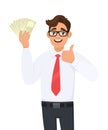 Young businessman showing cash, money and making thumb up gesture sign with hand fingers. Person holding currency notes. Royalty Free Stock Photo