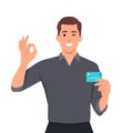 Young businessman showing credit, debit, ATM card and making okay or OK gesture sign with hand fingers. Person holding digital Royalty Free Stock Photo