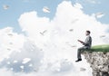 Man on edge reading book and paper planes flying in air Royalty Free Stock Photo